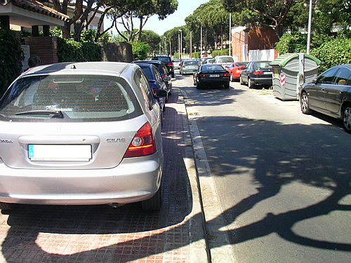 Fotografia realitzada l'estiu de l'any 2006 al carrer Cunit de Gavà Mar on es veu una filera de cotxes aparcats amb les quatre rodes sobre la vorera sense ser multats ni retirats per la grua municipal