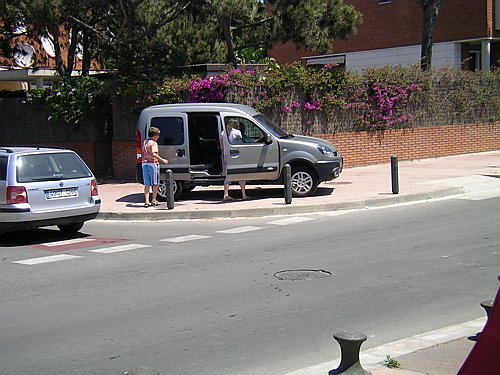 Fotografia realitzada l'estiu de l'any 2006 en un encreuament del carrer Tellinaires de Central Mar (Gavà Mar) on es pot veure un vehicle amb les quatre rodes sobre la vorera