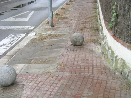 Bola de ciment situada en una vorera de l'encreuament dels carrers Blanes i Cunit de Gav Mar que impedeix el pas de persones de mobilitat reduïda i dels cotxets de nadons