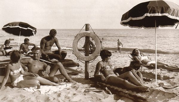 Un grup de turistes europeus prenent el sol a la platja del càmping Albatros (Any 1965)