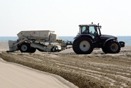 Tractor arrastrando arada y máquina cribadora en Gavà Mar